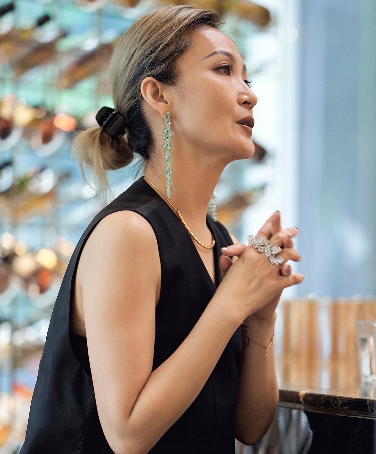 Woman in elegant attire with unique jewelry.