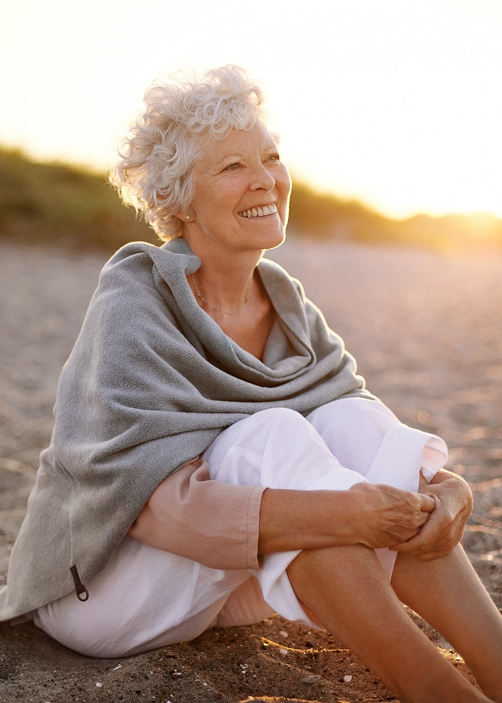 Model playing with hair in stylish outfit.