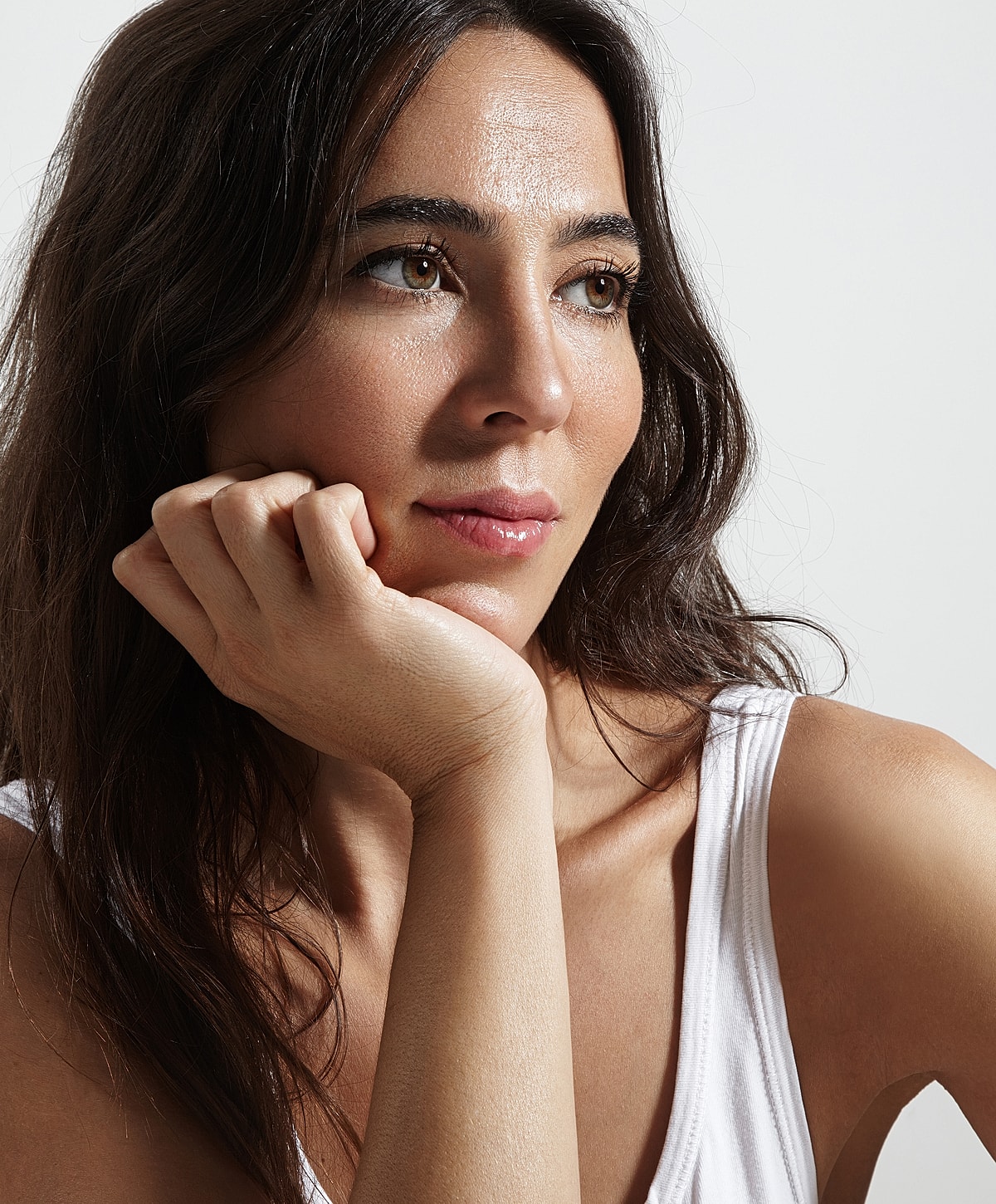Woman resting chin on hand, thoughtful expression.