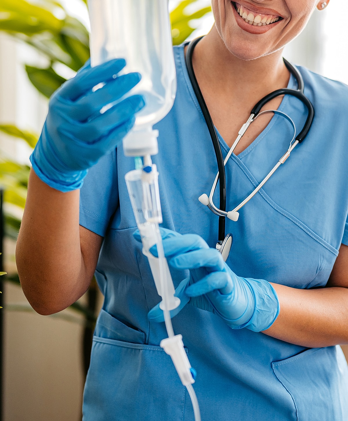 Nurse preparing IV drip with blue gloves.