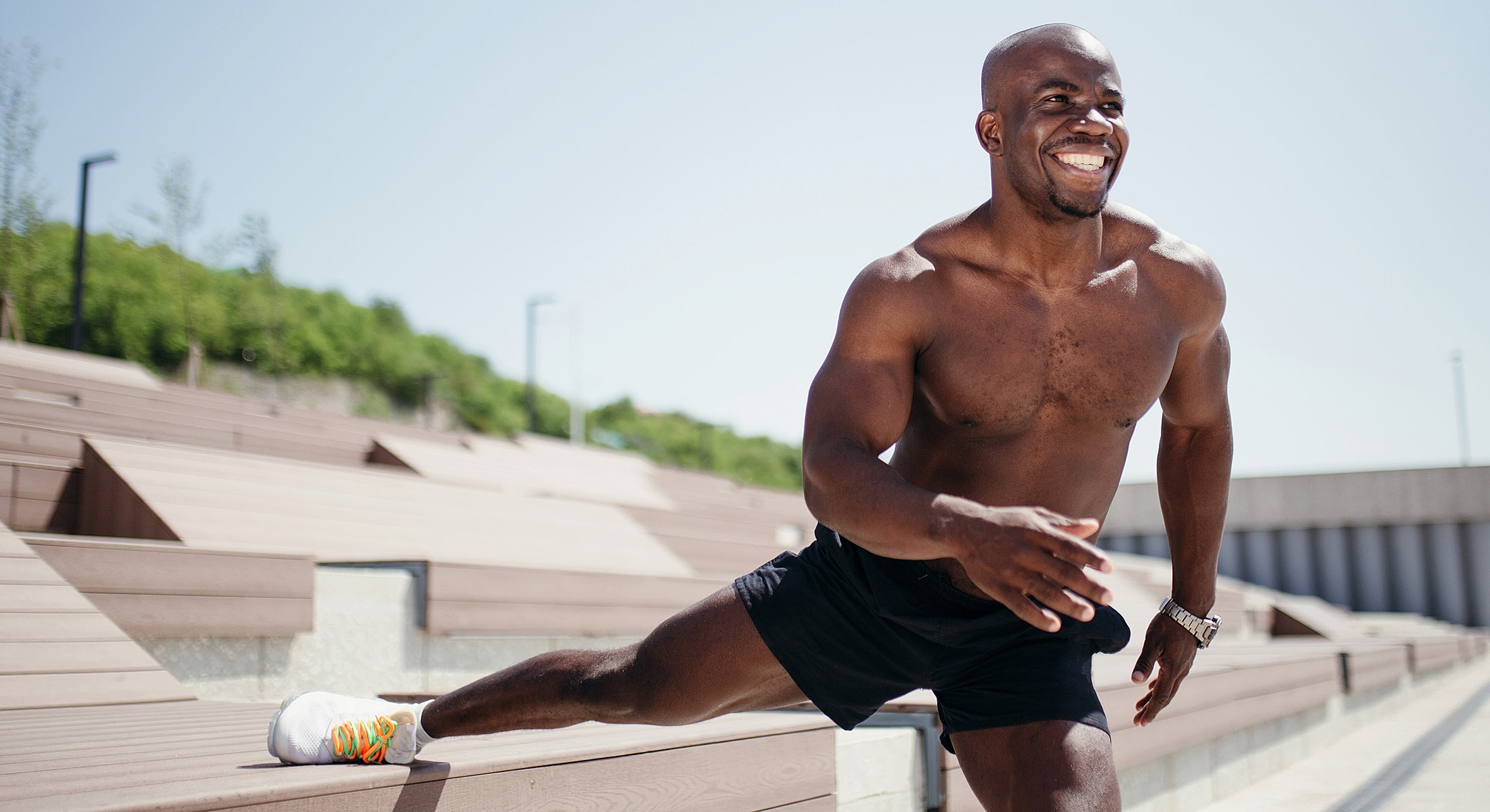 Man stretching outdoors on a sunny day.
